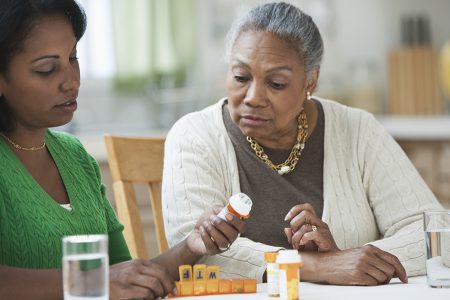 daughter assisting and explaining medicines to mother